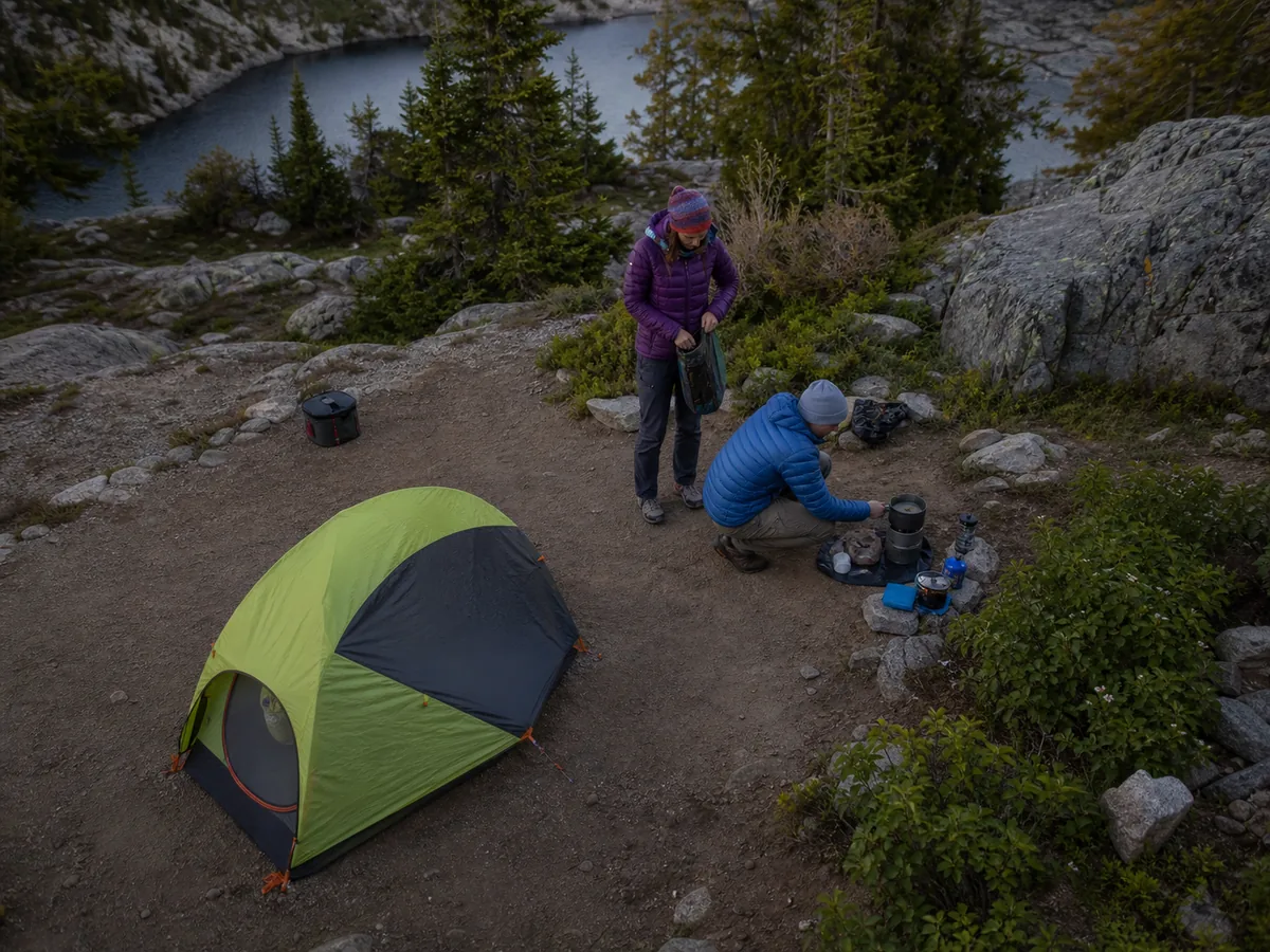 Generic backpacking campsite with shelter cooking water treatment and approved food storage organized in separate safe work areas - camp safety layout | KnowOutdoor