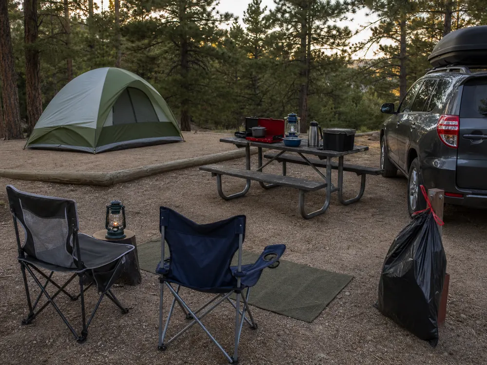 Car camping campsite zones with tent kitchen chairs vehicle and closed trash - car camping checklist | KnowOutdoor