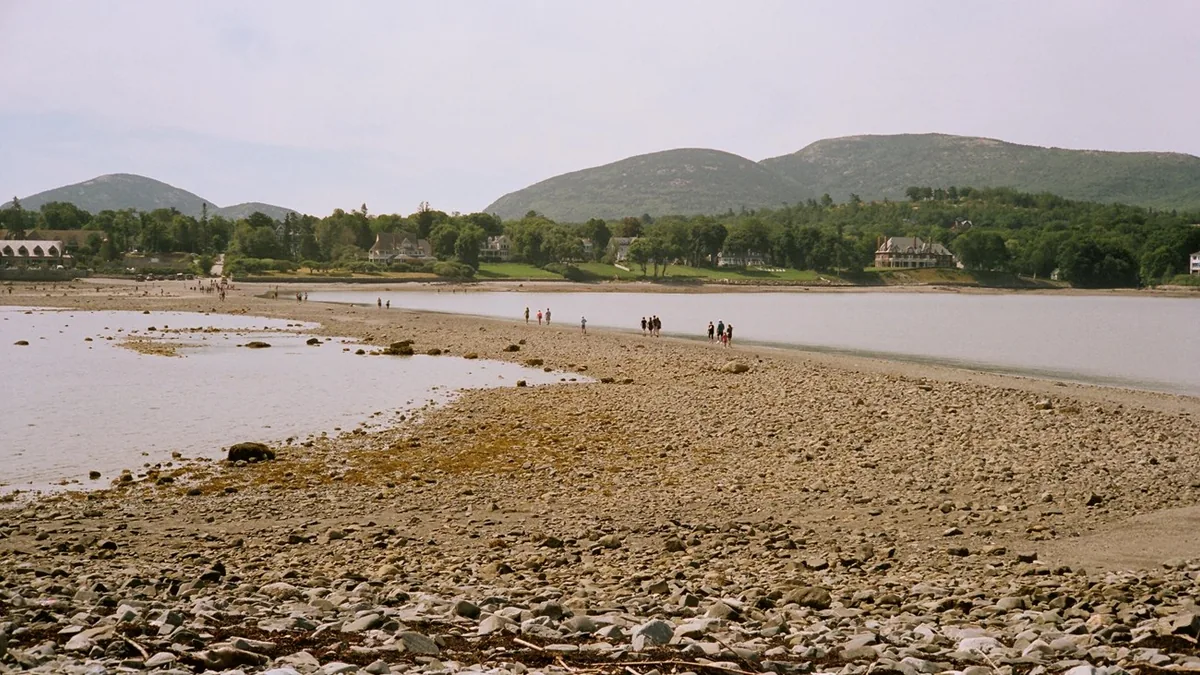 People crossing the exposed gravel bar between Bar Harbor and Bar Island at low tide - Acadia National Park | KnowOutdoor