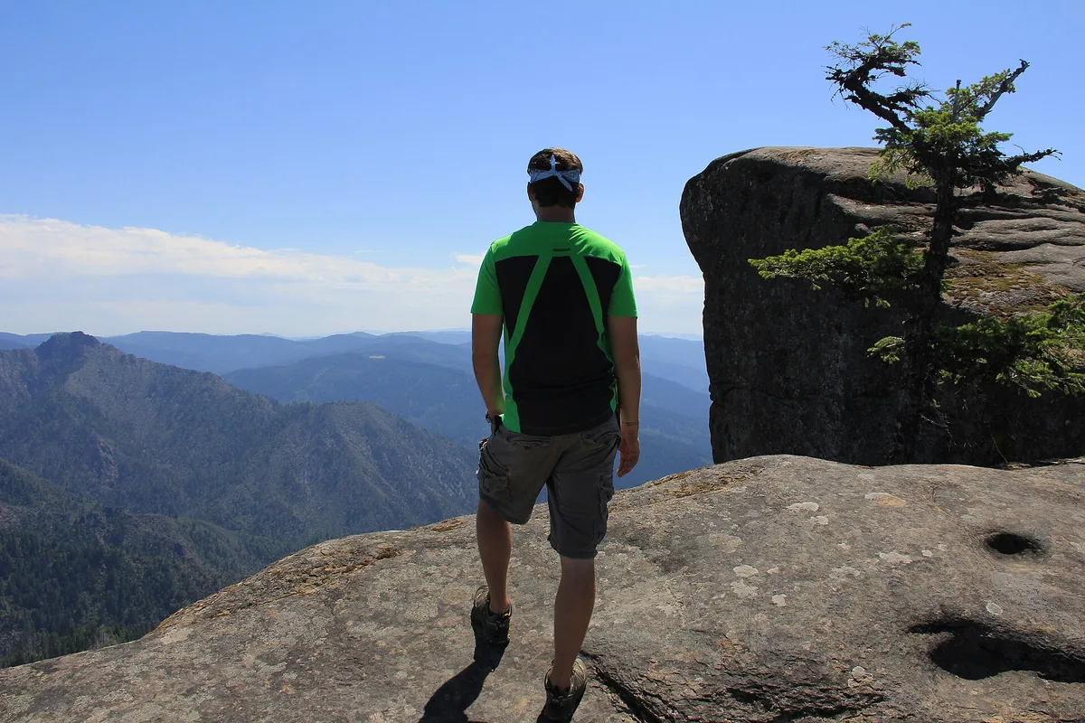 Hiker on an exposed rocky viewpoint with no nearby water - Water planning | KnowOutdoor