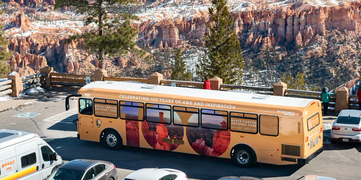 Bryce Canyon shuttle bus with red rock landscape behind it