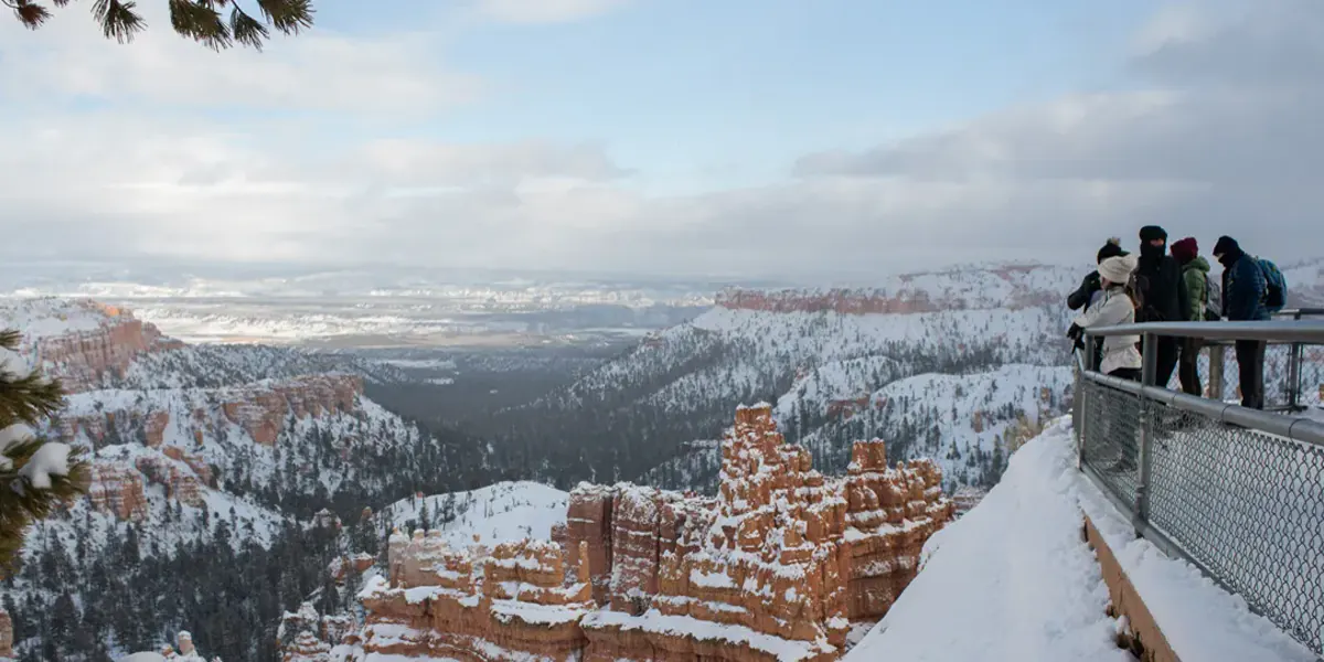 Visitors overlooking snow-covered hoodoos at Bryce Canyon National Park