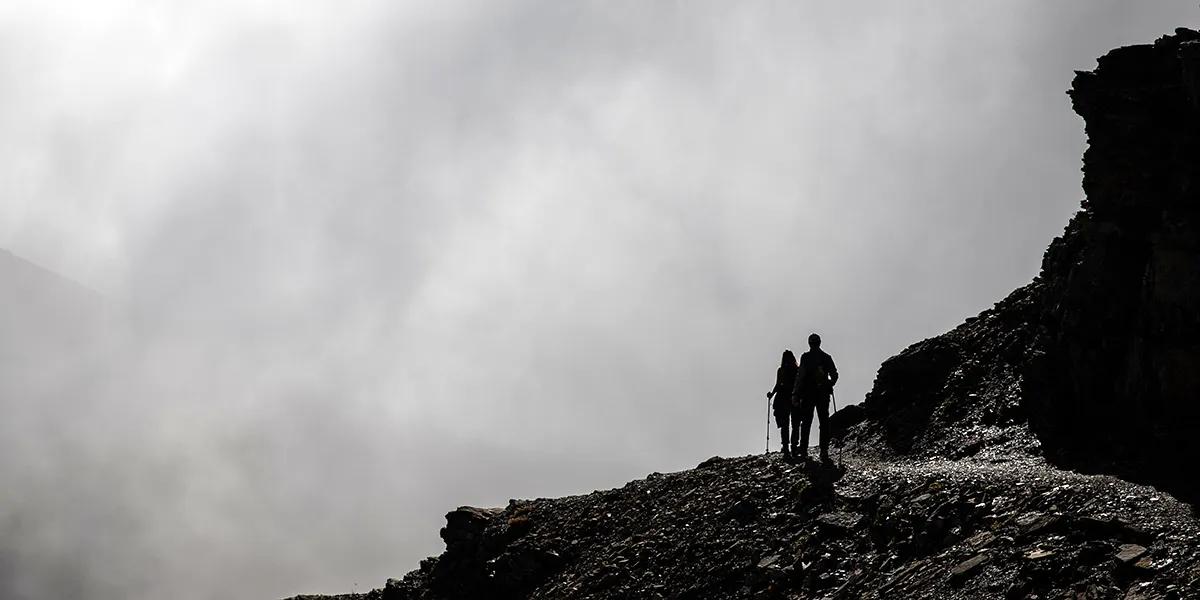 Hikers entering a cloud bank on the Highline Trail in Glacier National Park