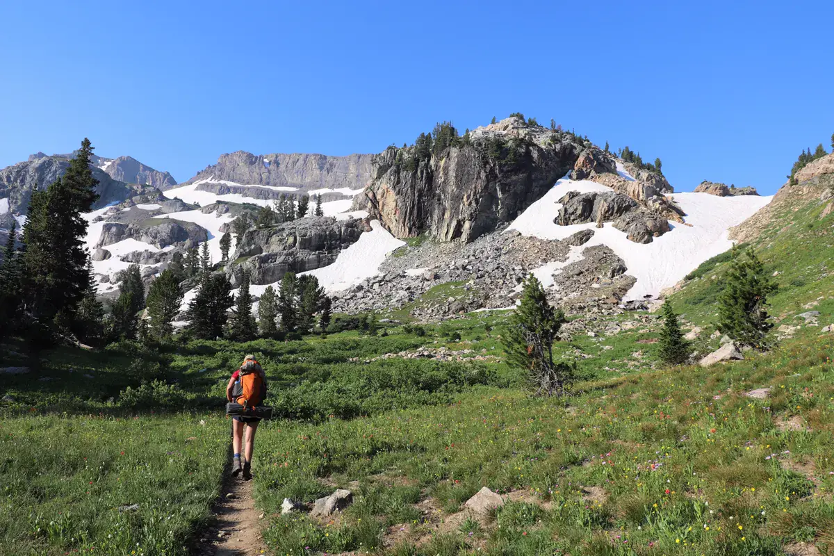 Backpacker walking through a mountain canyon in Grand Teton National Park