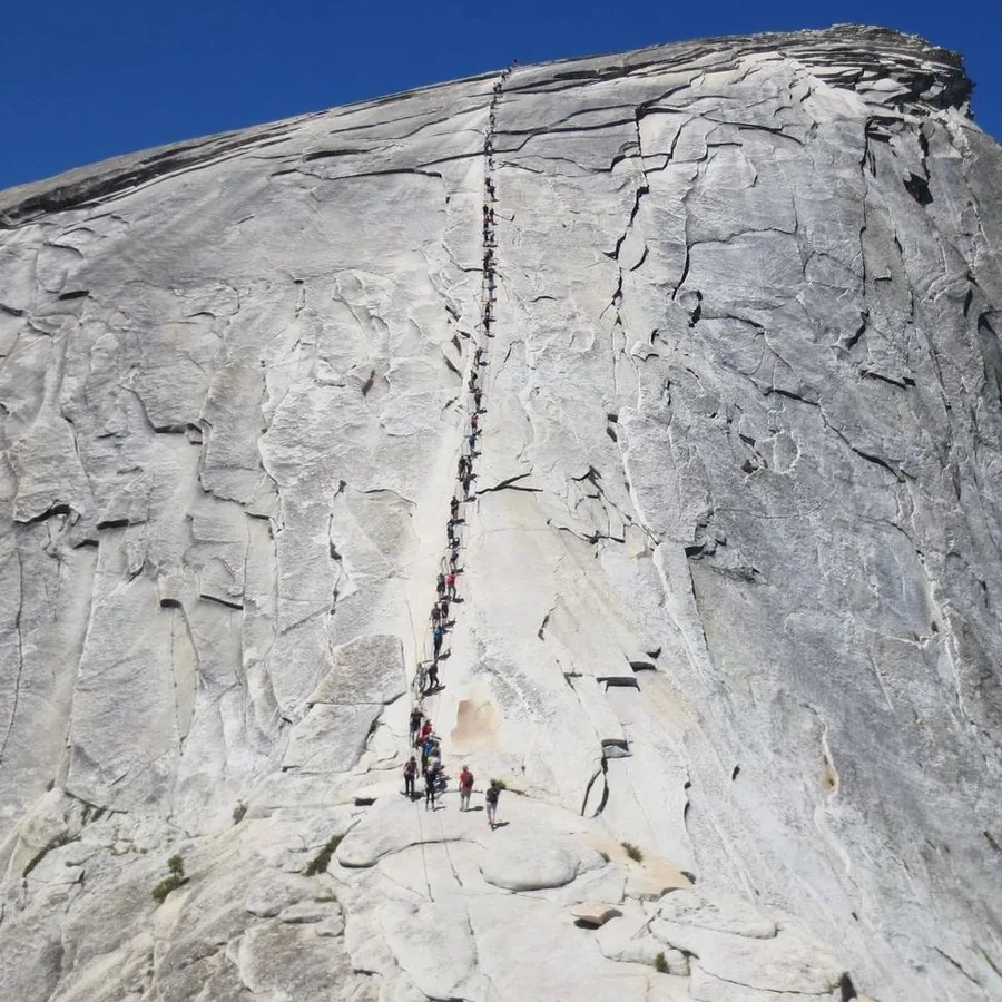 Hikers ascending the Half Dome cables where Yosemite requires a permit when cables are up - Yosemite National Park | KnowOutdoor