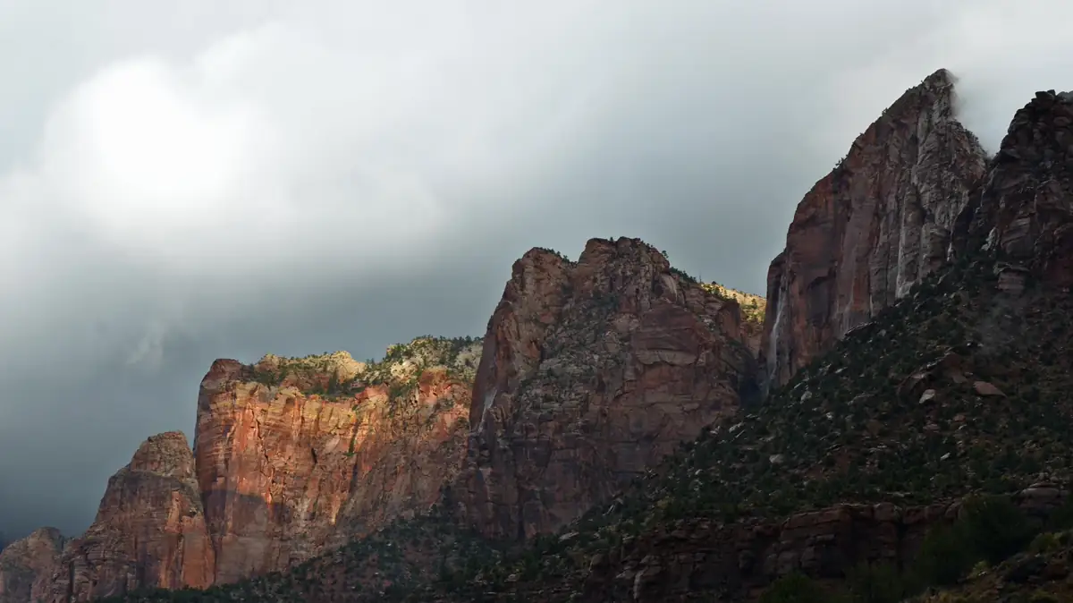 Dark storm clouds gathering above red cliffs in Zion National Park - Zion National Park | KnowOutdoor