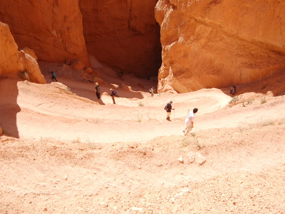 Hikers climb switchbacks through orange hoodoo walls - Bryce Canyon National Park | KnowOutdoor