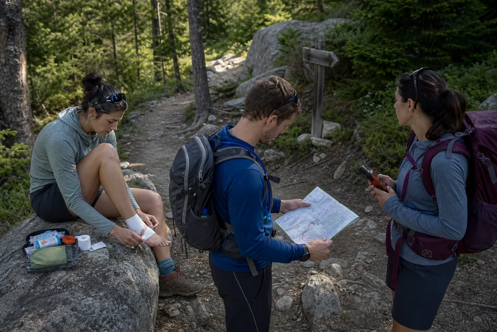 Hiking group comparing repair, shorten, turn around, and emergency help choices at a trail junction
