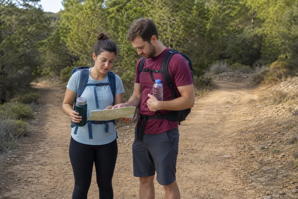 Beginner hikers confirming route, current conditions, water, finish time, and trusted-contact plan before leaving