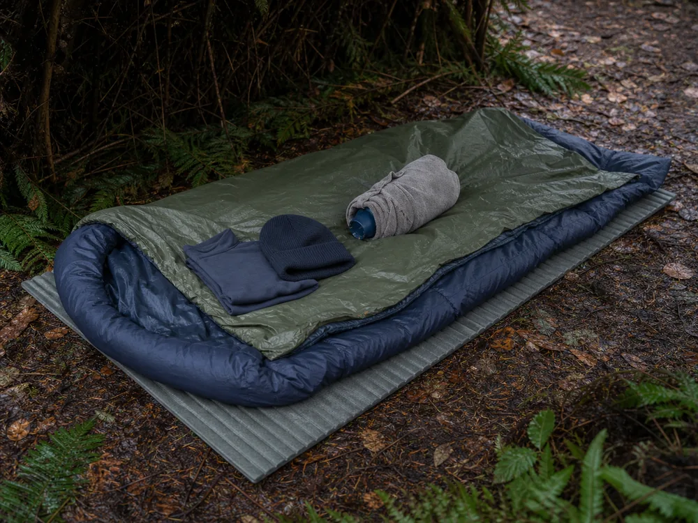Layered field rewarming kit with foam pad, dry insulation, vapor barrier, and protected torso heat pack