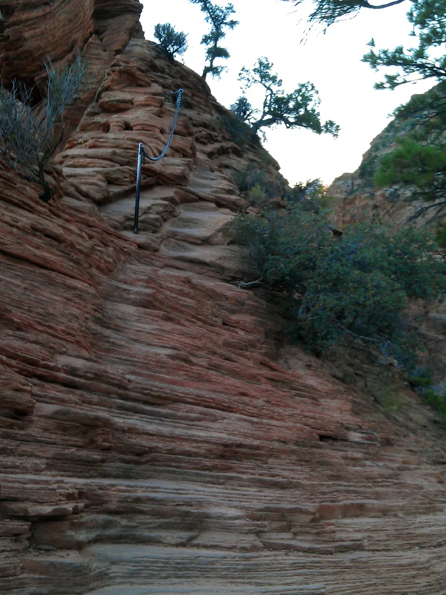 Close view of an installed chain crossing steep layered sandstone on Angels Landing