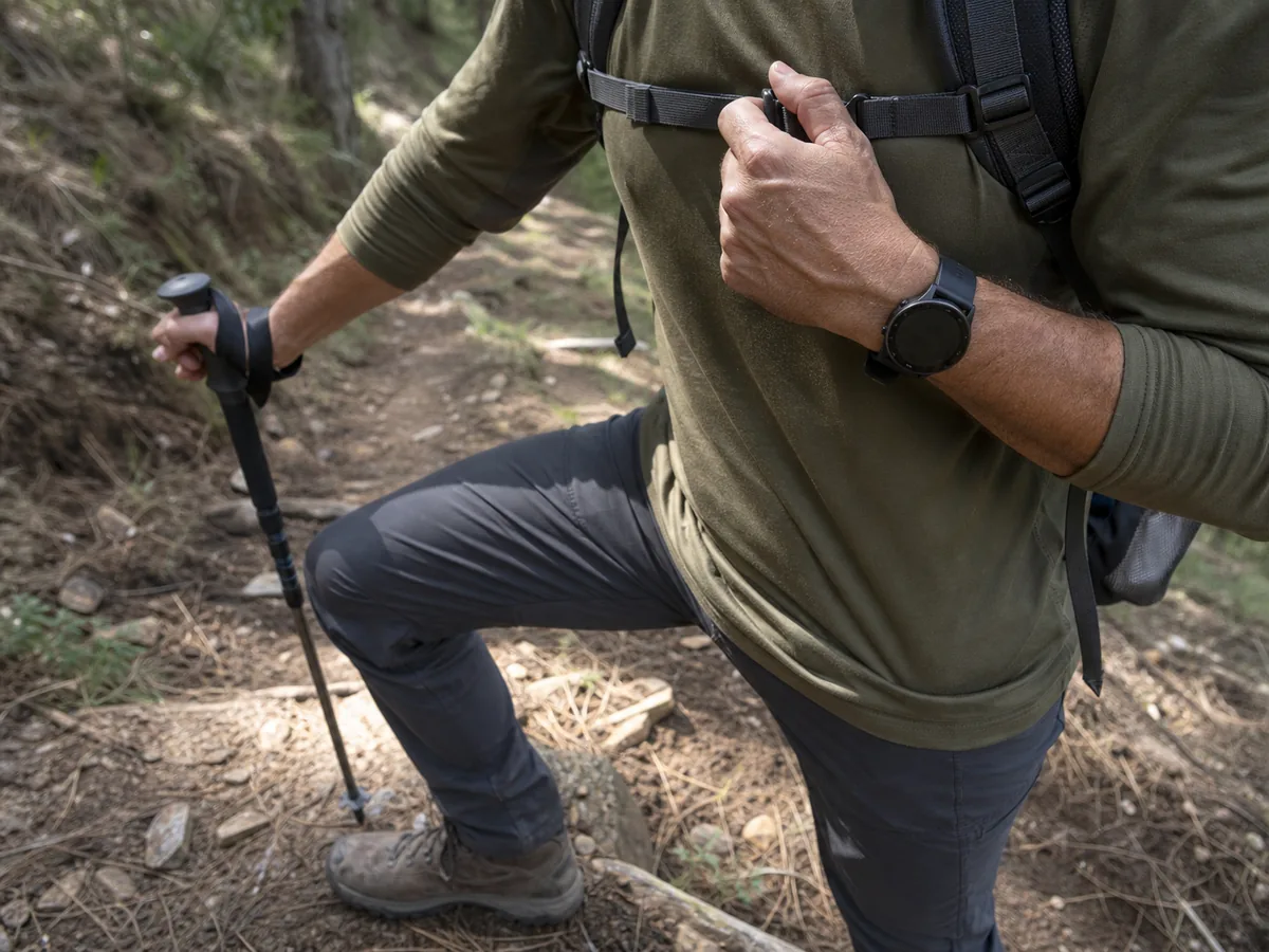 Trekker pausing on an uphill trail to check breathing and pace - trekking cardio effort | KnowOutdoor