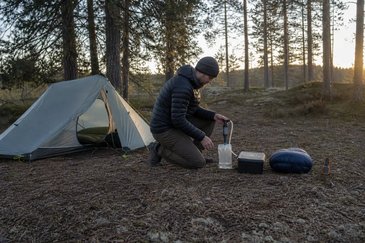 Solo trekker arranging dry shelter water treatment and food storage in a clear evening sequence - solo trekking camp sequence | KnowOutdoor